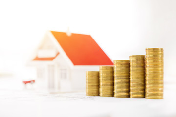 Money and house model on blueprint paper