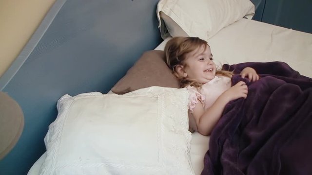 A little girl in her bed wakes up and discovers the gifts that the tooth fairy left under the pillow.
