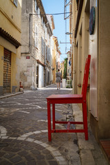 Fototapeta na wymiar Red chair in ancient alley