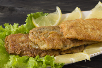 Fish in batter. Tasty and nutritious food. Fried fish on a wooden table.
