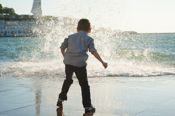 funny little boy on the background of a big wave - Powered by Adobe
