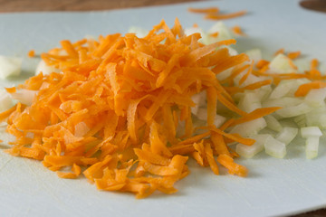 Grated carrots and chopped onions on a cutting board. Cooking homemade food. Healthy food.