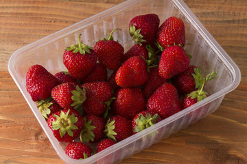 Strawberries in a plastic tray. Tasty and ripe berry. Seasonal delicacy.