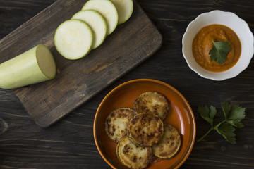 Fried zucchini in a clay bowl on a wooden table. Healthy food.