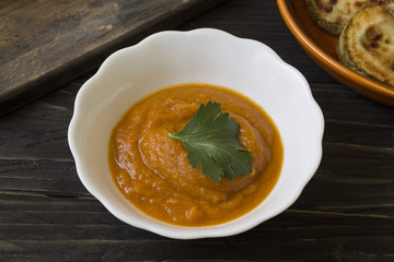 Squash caviar in a white bowl on a wooden table. Healthy food.