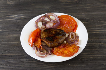 Fried meat with vegetables on a white plate. Tasty and nutritious dish.