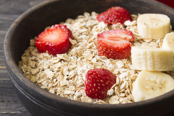 Oatmeal with fruit and berries on a wooden table. Healthy food. Tasty breakfast.