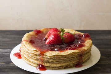 A pile of pancakes with strawberry jam. Delicious dessert.