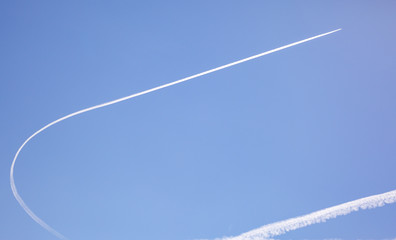 A curving contrail from a plane in the sky in Moab Utah