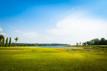 Fototapeta na wymiar green grass field with lake in public park