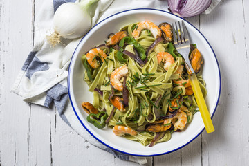 Green tagliatelle with seafood. Mussels; Prawns