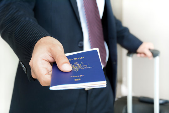 Businessman giving passport with boarding  pass inside