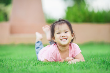 a kid playing on the green grass,Exploring and discovering nature environment and outdoor activity like play, touch and see the real things is the best learning method for children.