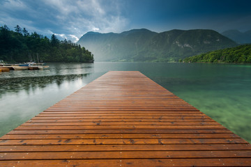 Fototapety  Spokojne i symetryczne drewniane molo nad jeziorem Bohijn, Słowenia