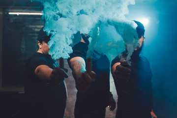 Three men vaping in an authentic room with brick walls