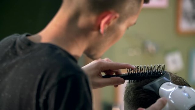 Hairdresser shearing a man