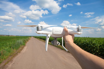drone in hand for a man on a background the green field