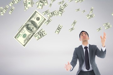 Business man looking at money rain against white background