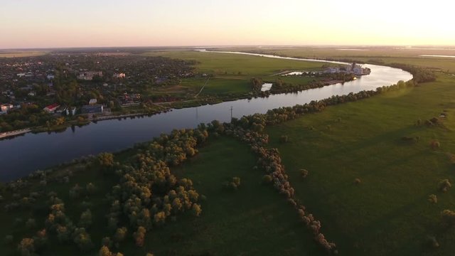 Wonderful view on the Dnipro river and its picturesque blue waters at sunset in summer. The riverbank is covered with fluffy green trees looks gorgeous and great. The skyscape is impressive