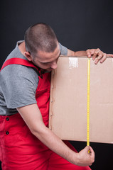 Mover guy holding box measuring with tape