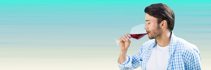 Man tasting wine against light blue background