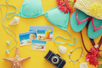 Obraz premium Top view of fashion female swimsuit bikini on yellow wooden background. Summer beach vacation concept