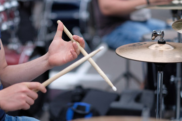 The drummer's hands with chopsticks behind the drum set. Baltic Drum Summit 2017. Riga, Latvia.