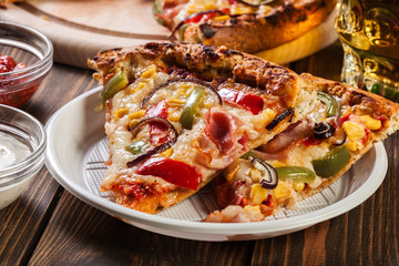 Slices of pizza with bacon, paprika and corn
