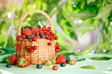 Ripe berries in a basket on a wooden table.