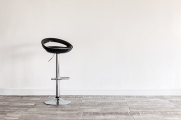 Black bar stool in front of wall.