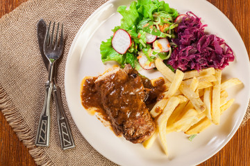 Pork roulade with french fries with salad