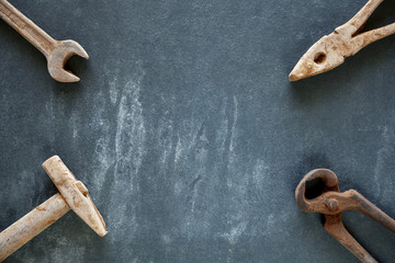 Rusty like tools made of chocolate on a dark slate background, copy space in the middle.