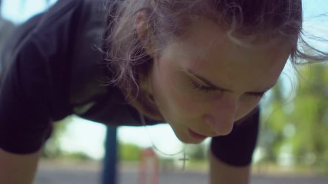 Attractive woman doing trx handles training in a park
