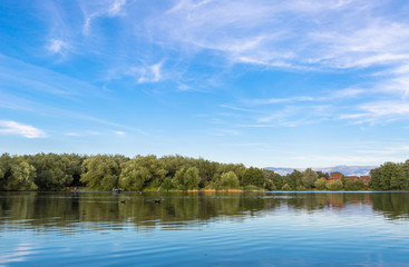 Fototapeta na wymiar Summer lake landscape with green trees and bush, Woking, Surrey