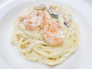 Pasta Carbonara with seafood on a white plate