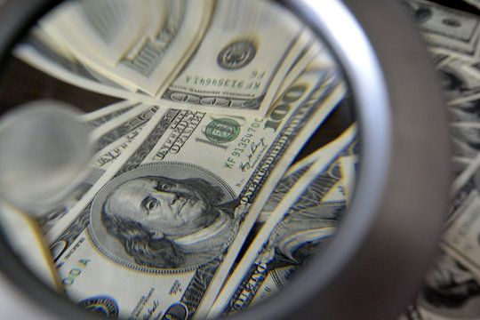 Dollars and magnifying glass