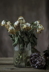 Dried roses in vase with dramatic lighting