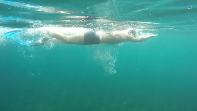 swimmer in flippers swim into the sea, raw, 4K