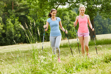 Zwei junge Frauen beim Nordic Walking
