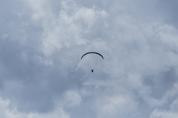 silhouette of paraglider in dark clouds