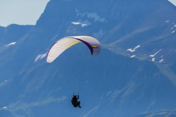 one person paragliding in the mountains