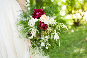 Beautiful bouquet of peonies in woman's hands