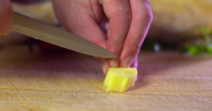 Man slices fresh ginger into thin strips