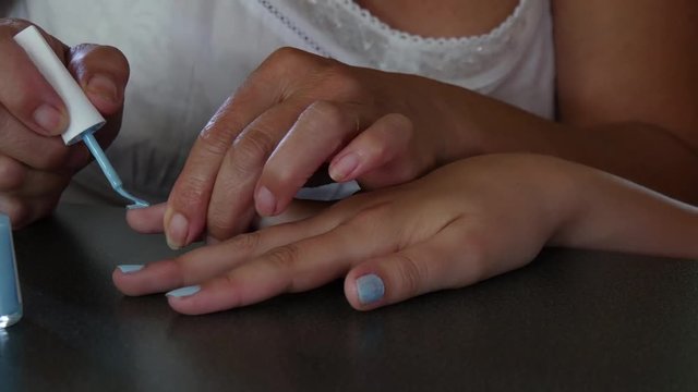 teenager puting on blue nail polish