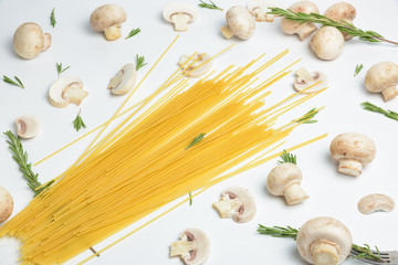 Italian spaghetti with mushrooms on table. Sliced champignon, rosemary and long, thin, cylindrical, solid pasta on a white background