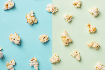 The popcorn in paper cup on green and blue background.