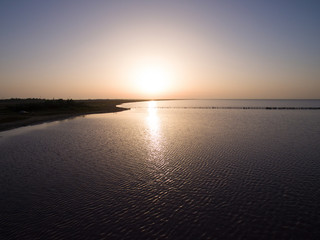 Landscape of lake at sunset / Water surface in golden glow of sunset
