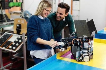 Young students of robotics preparing robot for testing