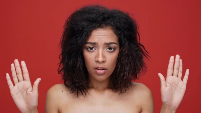 Young african woman says no over red background