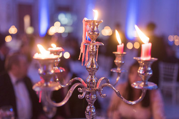 Candlestick with lighted candles and beautiful reflections photographed at wedding time